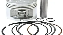 Motorcycle piston kit parts laid out for an engine upgrade
