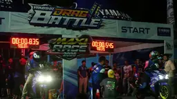 Drag bike racers staged at the starting line of a night drag race with floodlights