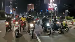 Group of Indonesian riders on a night ride through the city streets
