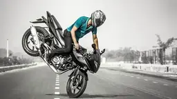 Motorcycle doing a wheelie stunt on an empty road